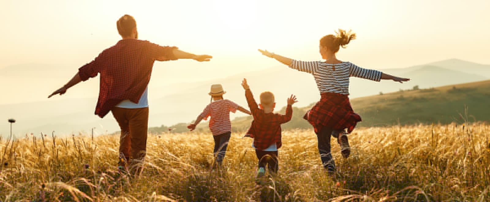 A young family running through a field