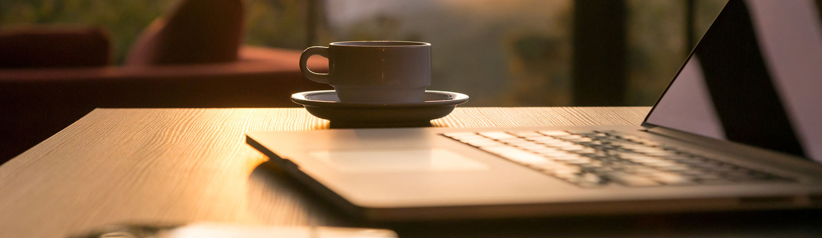 a laptop and coffee cup sitting on a tablet