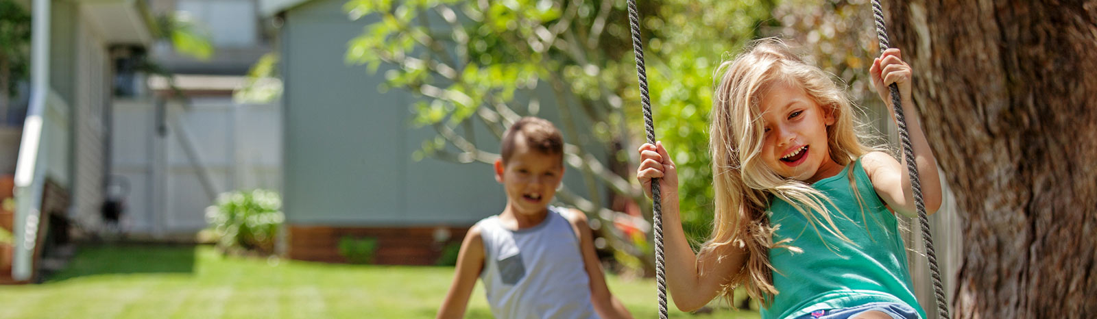 Two kids playing on a swing