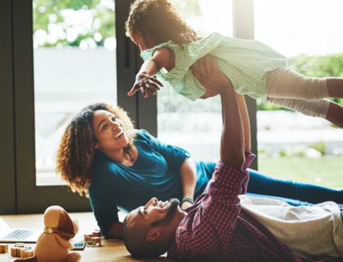 two parents playing with a young girl