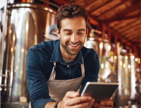 a man in an apron using a tablet