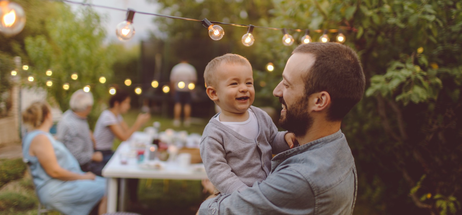 a dad holding a small child outside