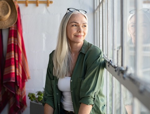 an adult woman looking out a window